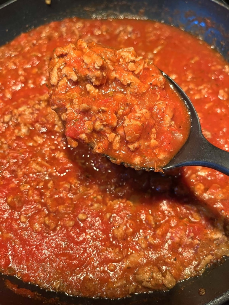 spoon scooping up ground beef in Ground Turkey Bolognese Sauce