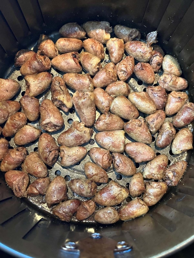 golden brown chicken hearts in an air fryer basket