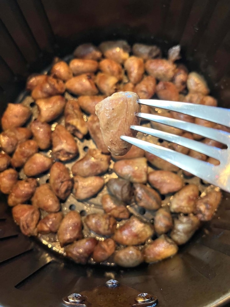 fork holding chicken heart with light seasoning