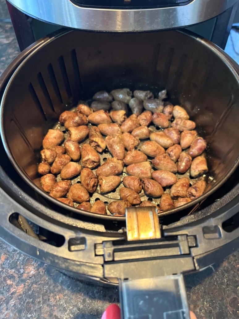 air fryer opened to show cooked chicken hearts inside