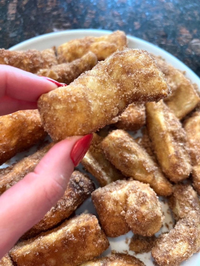 hand holding Air Fryer Churro topped with cinnamon sugar