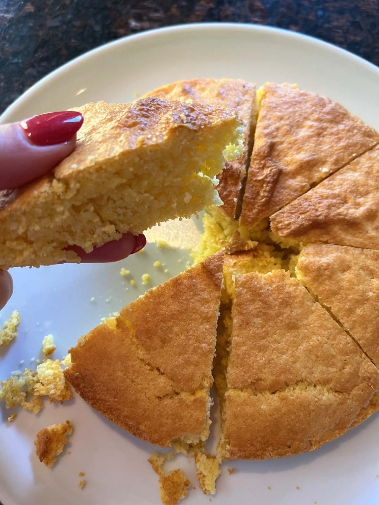 hand holding slice of moist and tender Air Fryer Cornbread