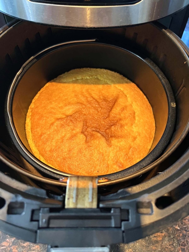 air fryer opened to show 3 ingredient cornbread baking inside