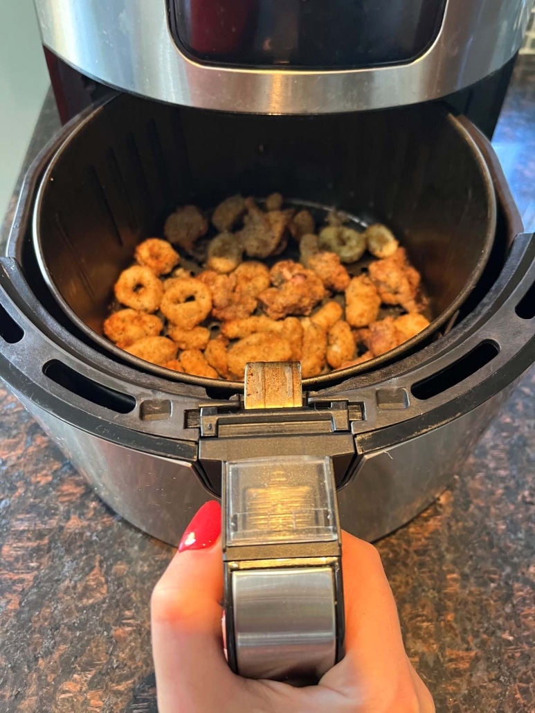 air fryer opened to show crispy breaded calamari inside