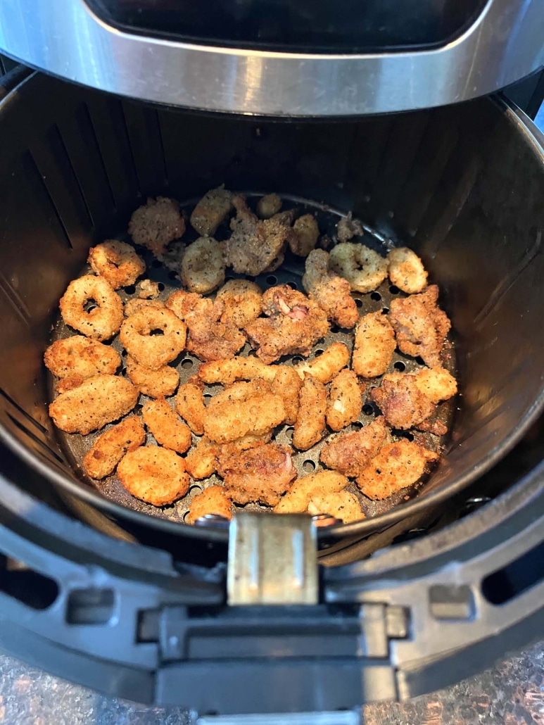 air fryer opened to show perfectly tender cooked calamari