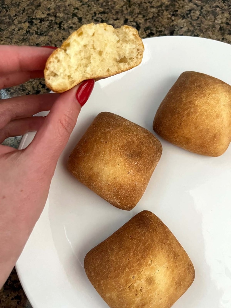 hand holding Frozen Dinner Roll heated in air fryer