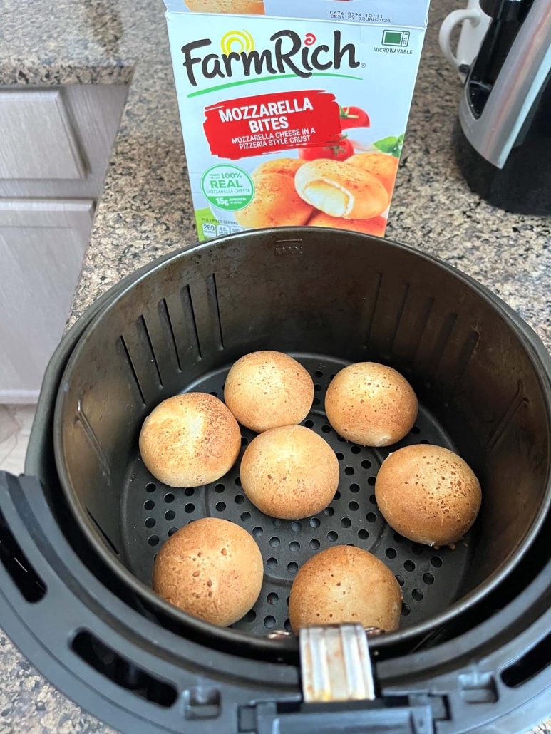 golden brown Farm Rich Mozzarella Bites in the air fryer basket next to a package of Farm Rich Mozzarella Bites