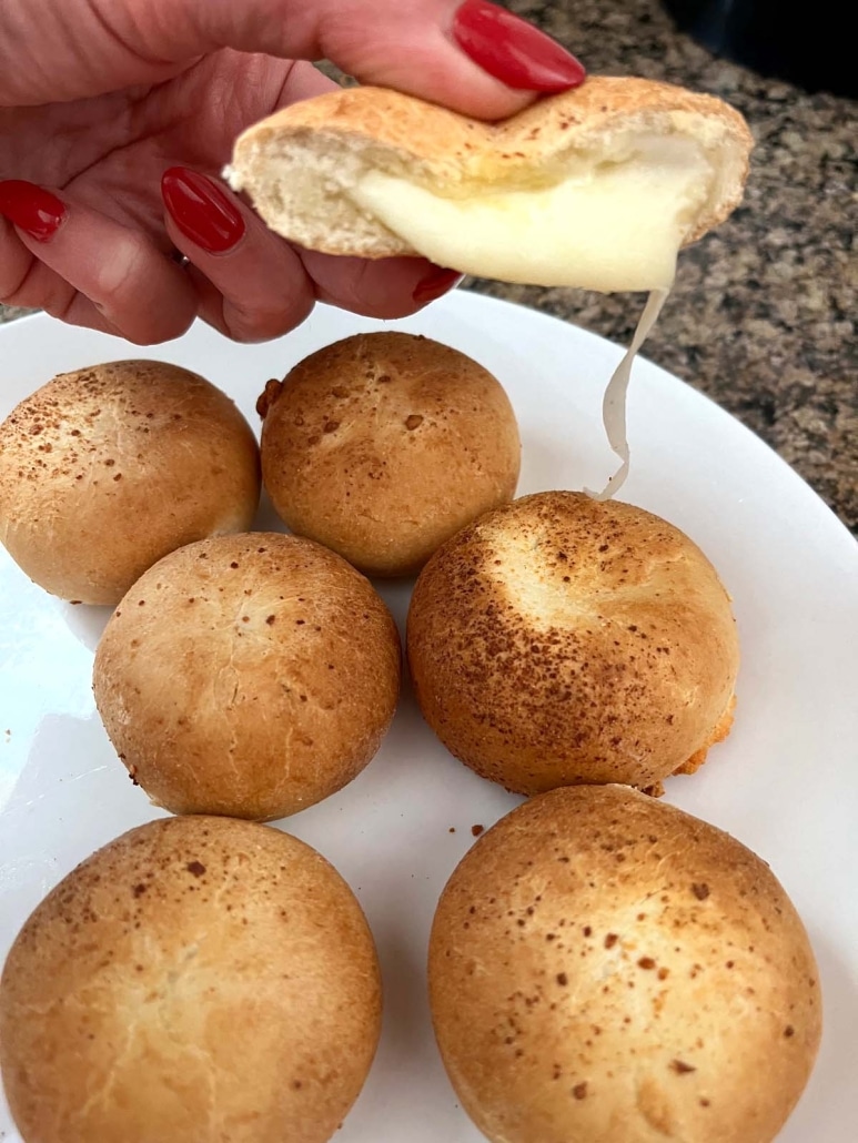 hand holding half of a mozzarella bite with gooey cheese