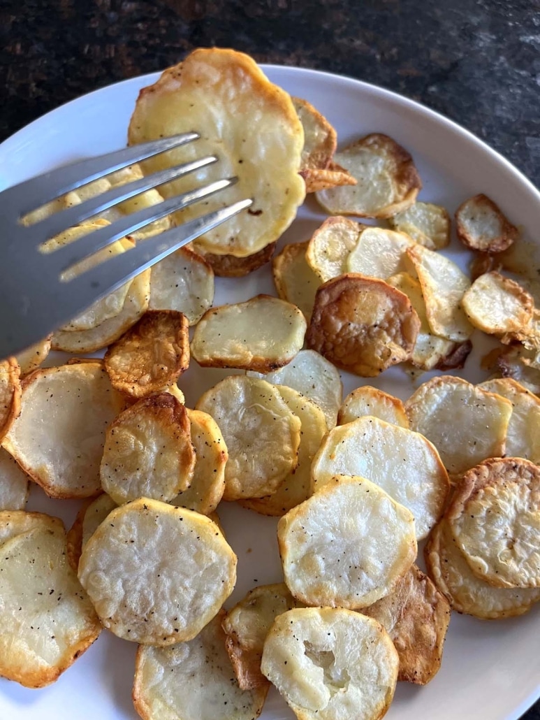 fork holding slice of air fryer potatoes