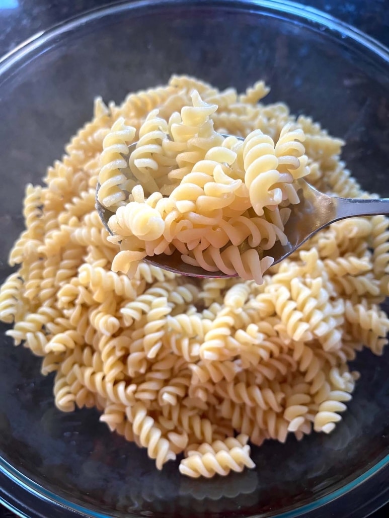 fork holding bite of microwaved pasta