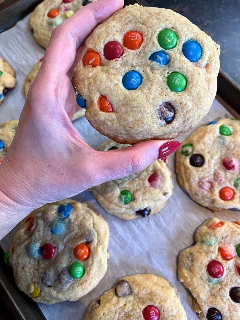 hand holding delicious and chewy M&M Cookie