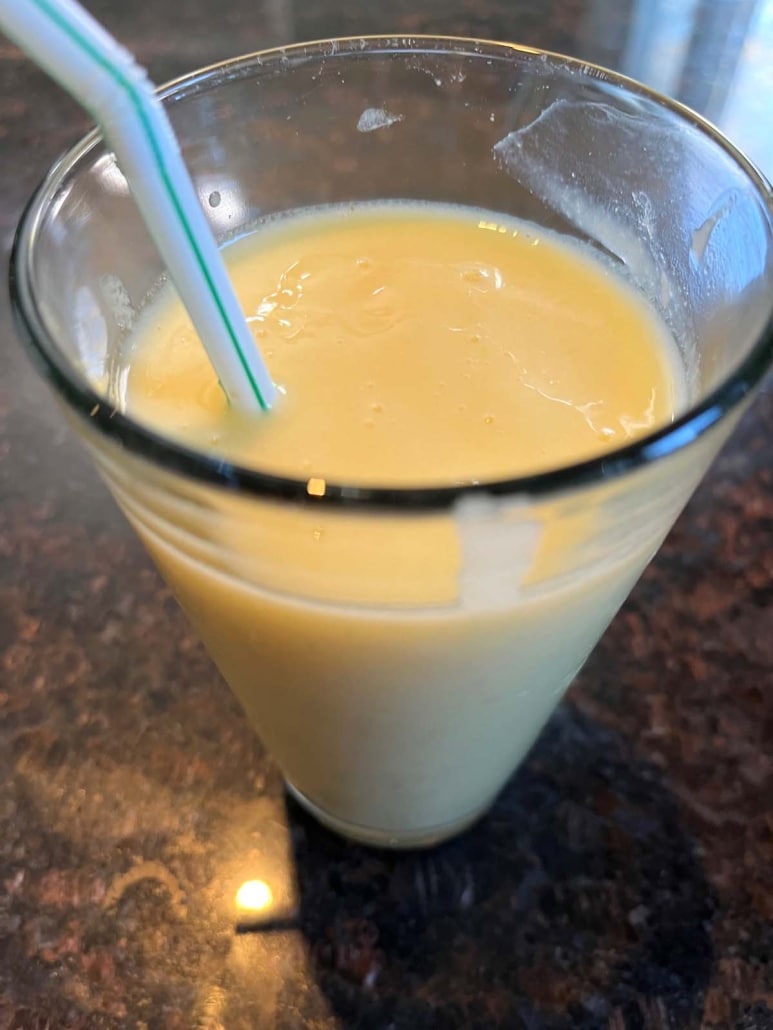 Mango Pineapple Smoothie with a straw in it