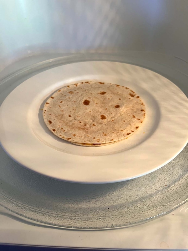 cheese quesadilla on a microwave-safe plate in the microwave