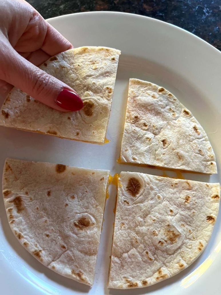 hand picking up a slice of Microwave Cheese Quesadilla