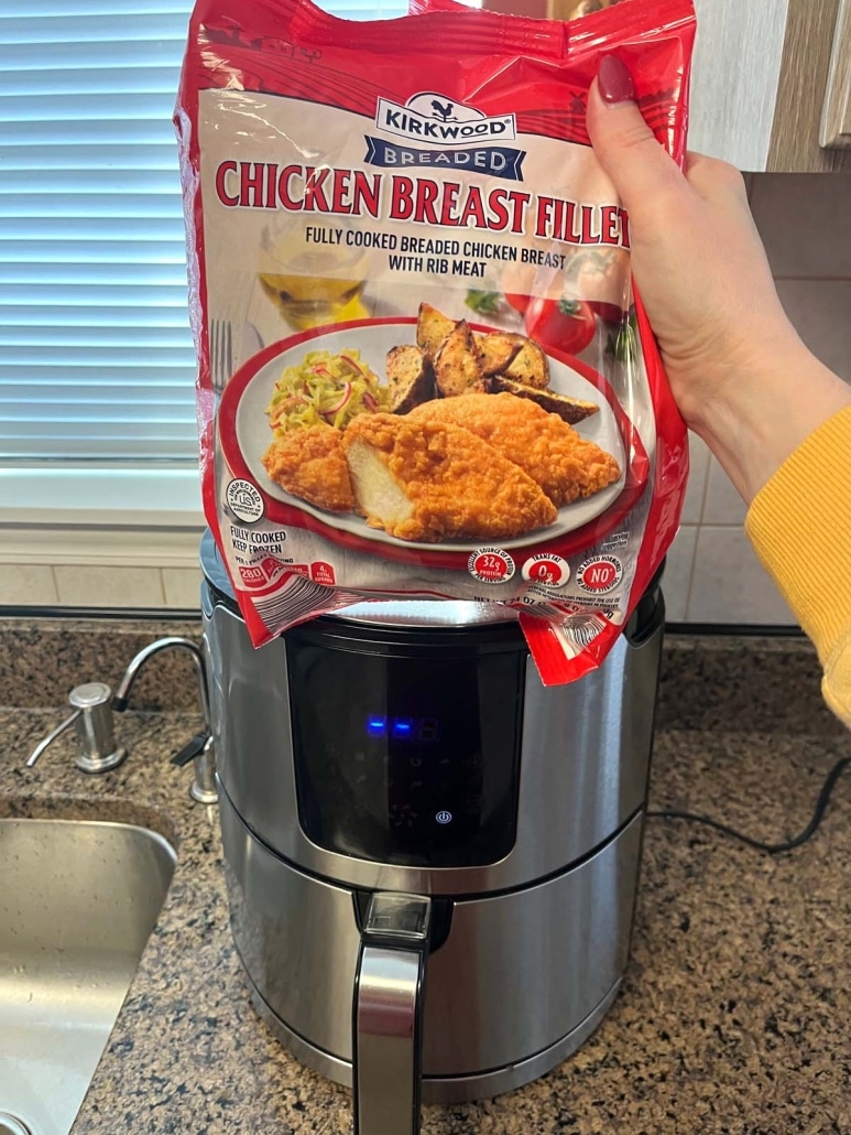 package of frozen Aldi red bag chicken next to an air fryer