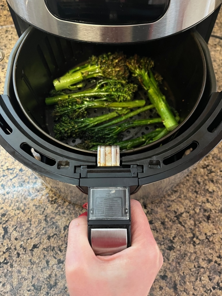 air fryer opened to show cooked broccolini inside