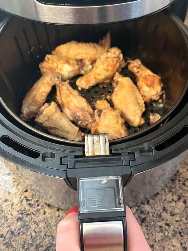 air fryer opened to show crispy chicken wings inside