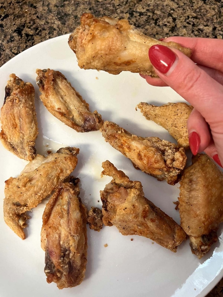 hand holding crispy chicken cooked in the air fryer