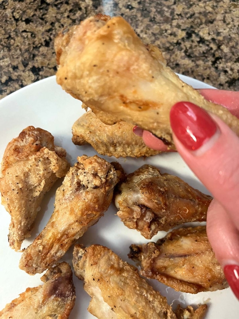 hand holding air fried chicken wing