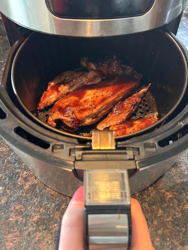 air fryer opened to show cooked pork rib tips