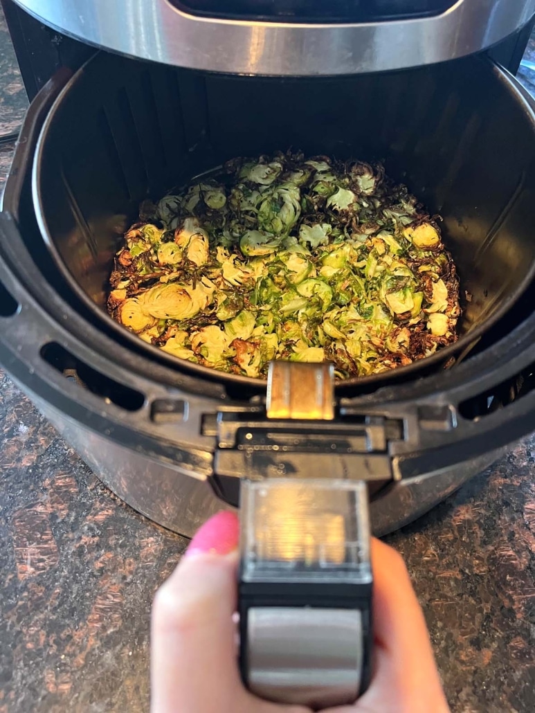 air fryer opened to show cooking brussels sprouts inside