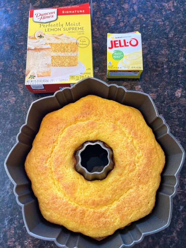 lemon bundt cake next to a package of Duncan Hines lemon cake mix and Jello lemon pudding mix