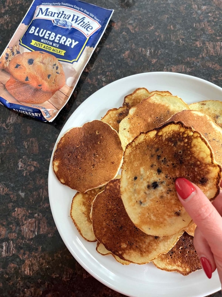 hand holding Muffin Mix Pancake next to a box of muffin mix