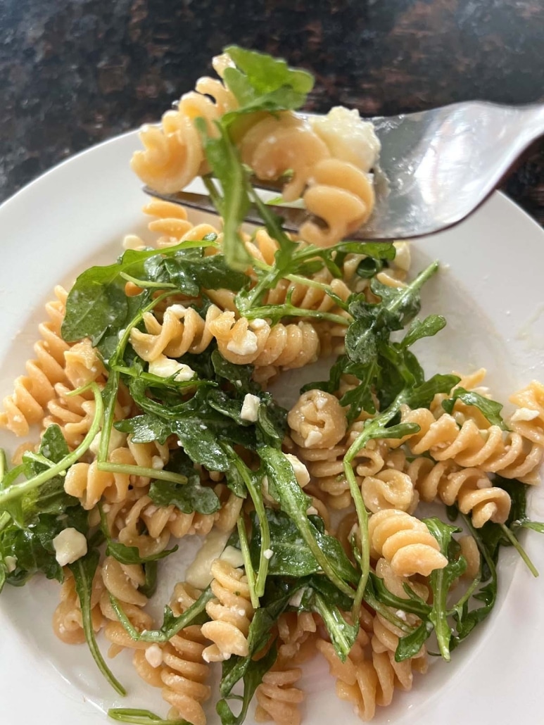 fork holding bite of refreshing Arugula Pasta Salad