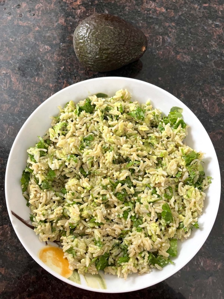 bowl of easy side dish Avocado Rice, next to an avocado