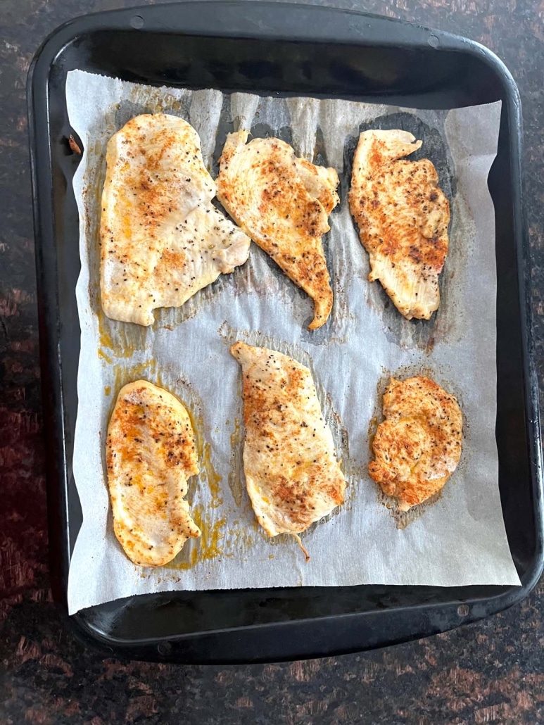 baking sheet with chicken cutlets on top