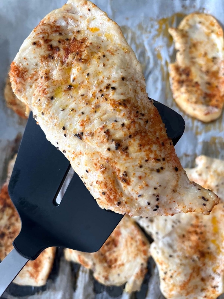spatula holding a tender and flavorful Baked Chicken Cutlet
