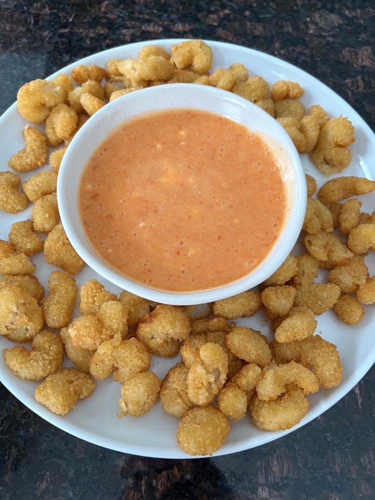 bowl of bang bang sauce, surrounded by popcorn shrimp