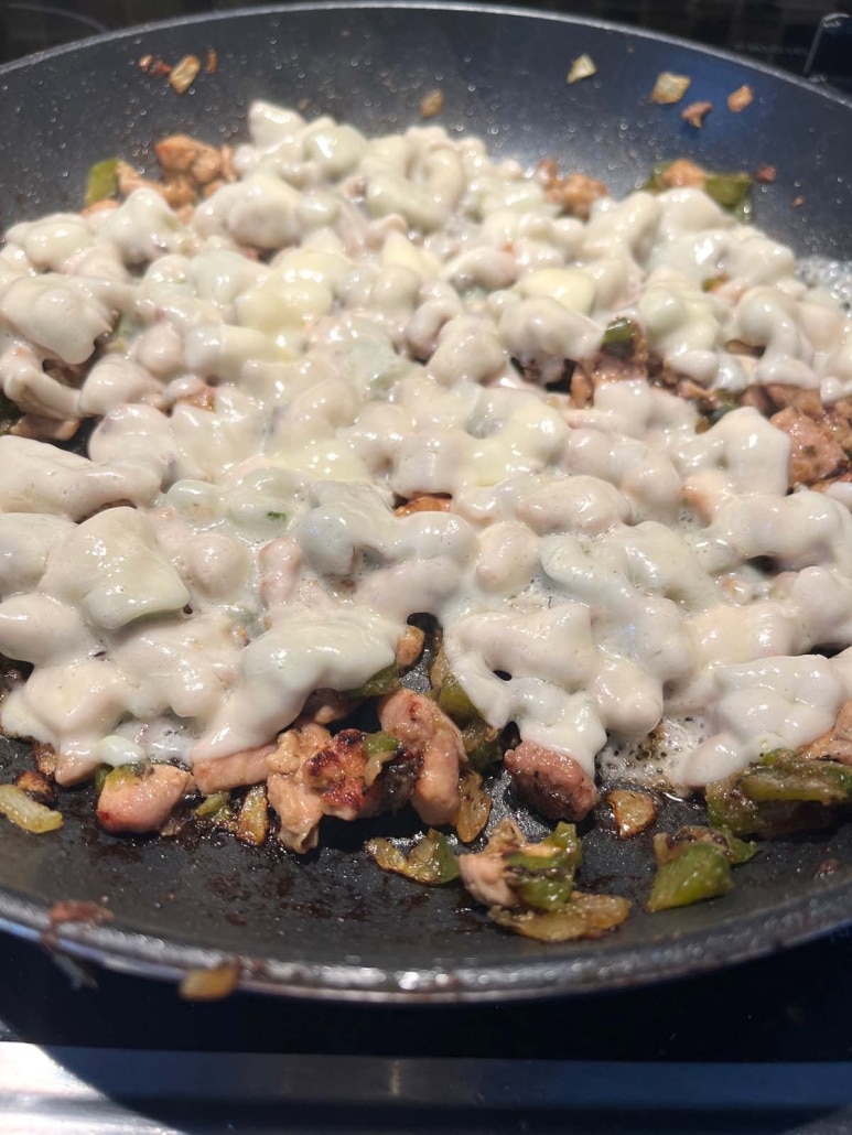 warm Chicken Philly Cheesesteak ingredients in a skillet