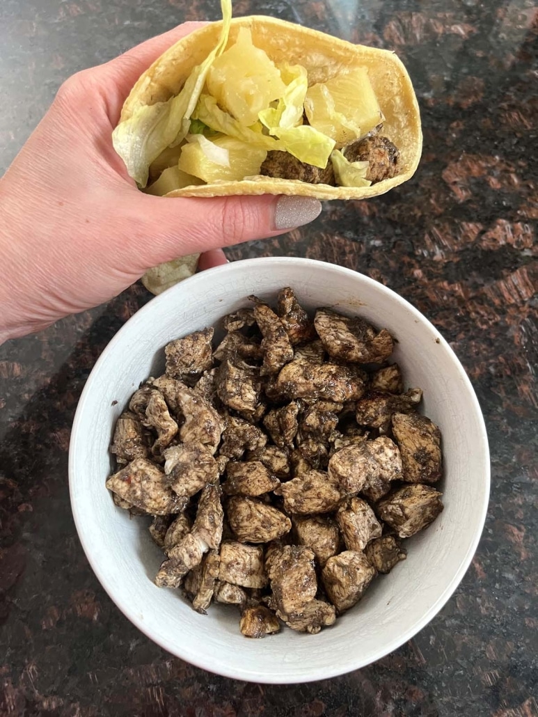 Jerk Chicken Taco next to a bowl of seasoned chicken