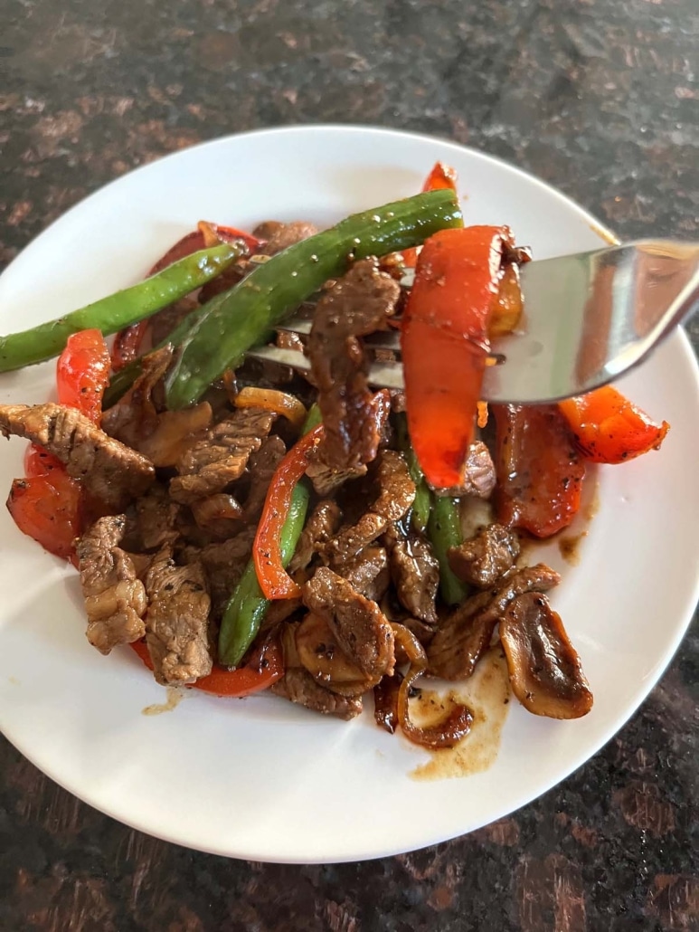 forkful of black pepper angus steak and vegetables