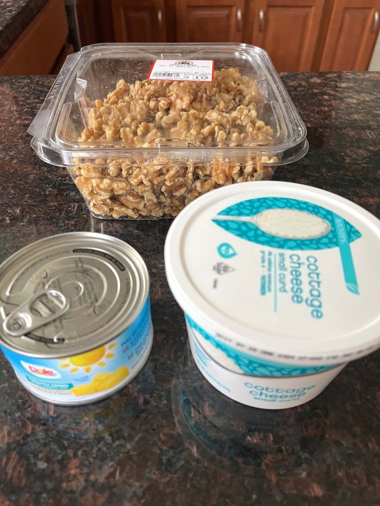 a container of cottage cheese, a can of pineapple chunks, and a container of walnuts on a countertop