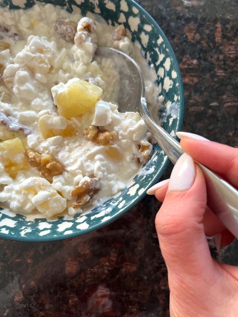 hand scooping up a spoonful of healthy breakfast Cottage Cheese And Pineapple