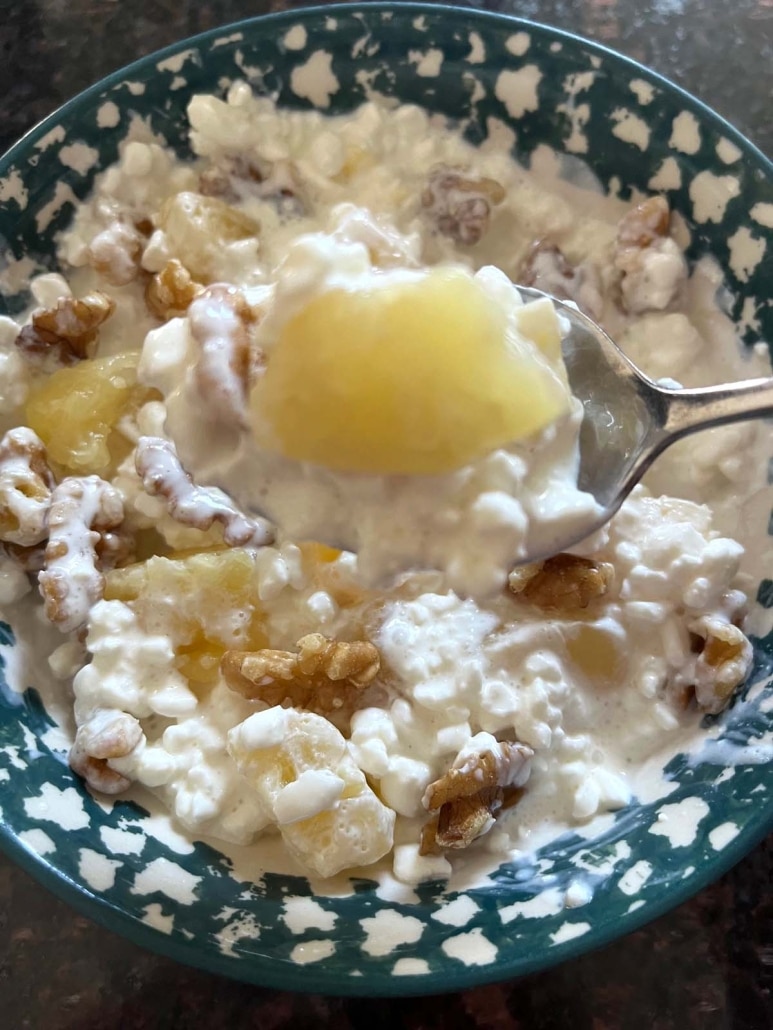 scooping up a spoonful of cottage cheese with fresh fruit