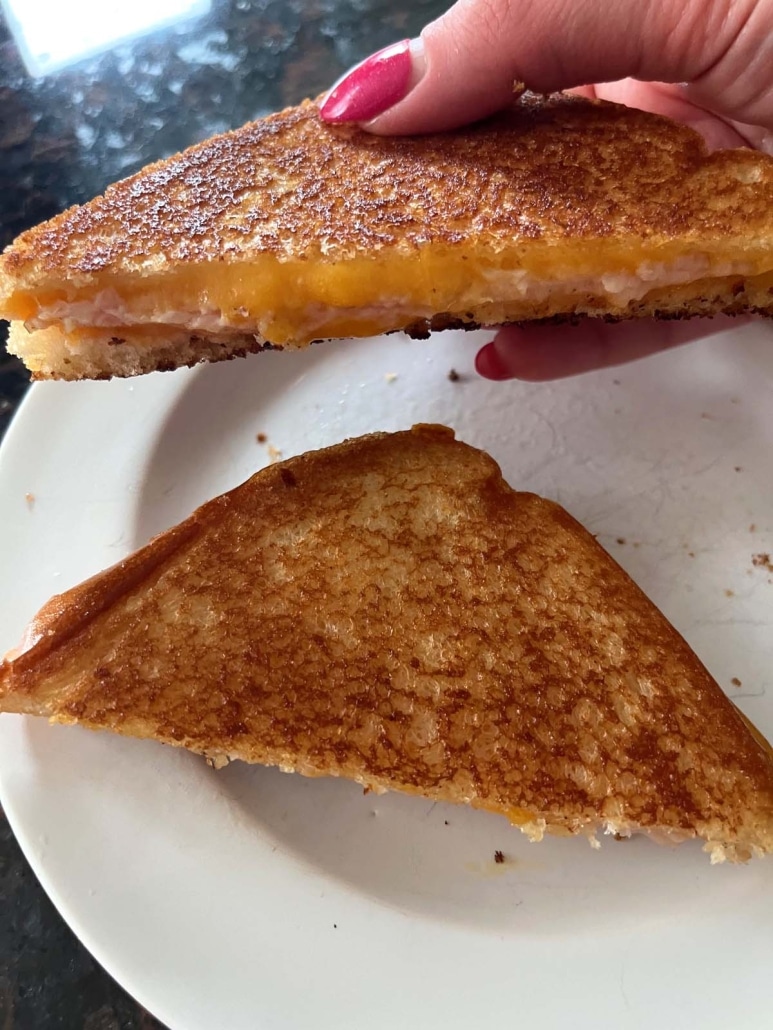 hand holding half of a Grilled Turkey And Cheese Sandwich