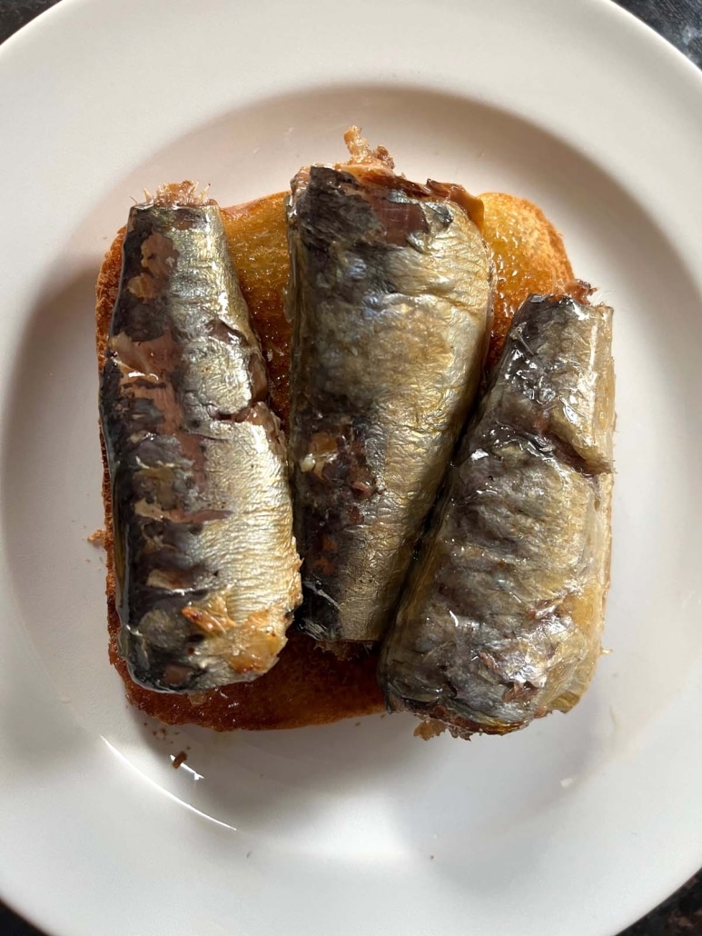 olive oil-covered sardines on a piece of golden brown toast