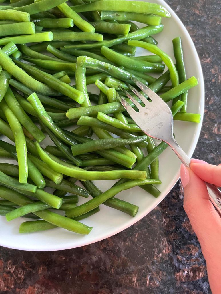 fork holding blanched green beans