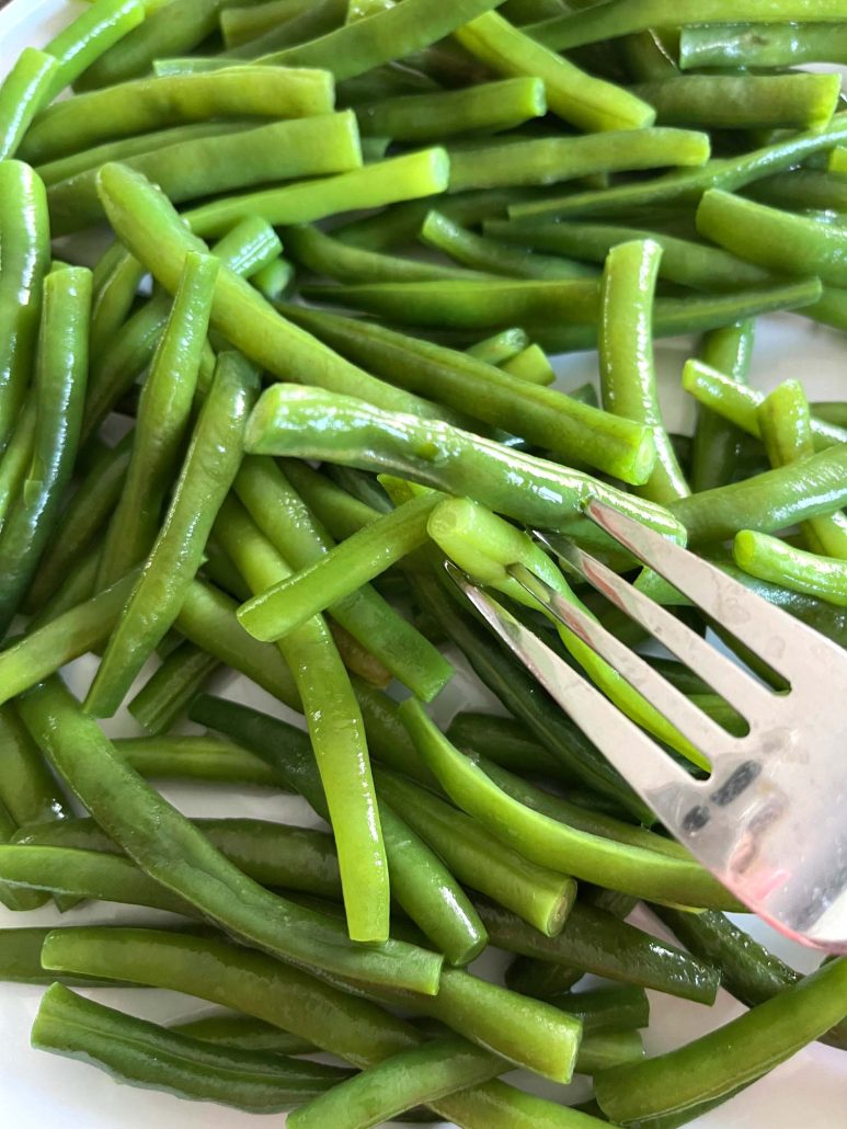 fork with bite of healthy dish blanched green beans