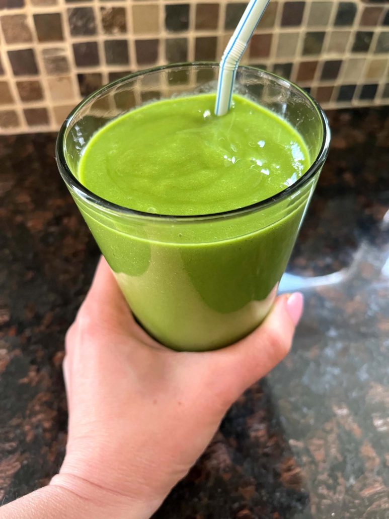 hand holding a healthy Mango Spinach Smoothie