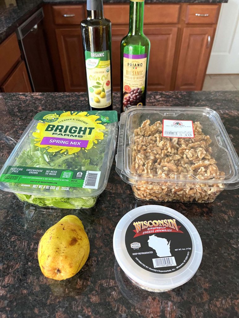 ingredients for Pear And Gorgonzola Salad: salad, walnuts, gorgonzola crumbles, olive oil, balsamic vinegar, and a lemon