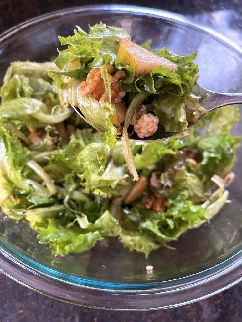 tossing up a bowl of side dish Pear And Gorgonzola Salad