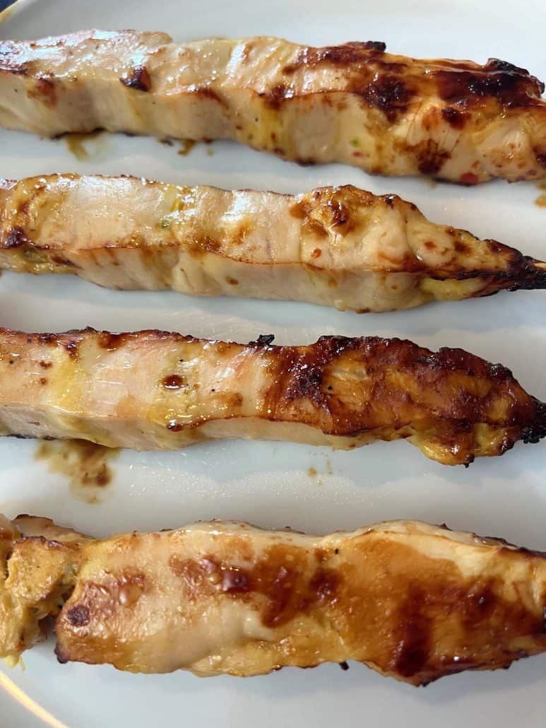 Close-up of four chicken breast skewers.