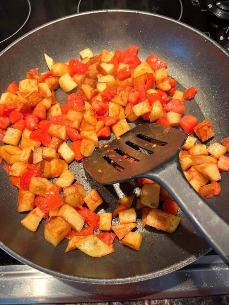 Fried potatoes and tomatoes on a non-sticky pan.