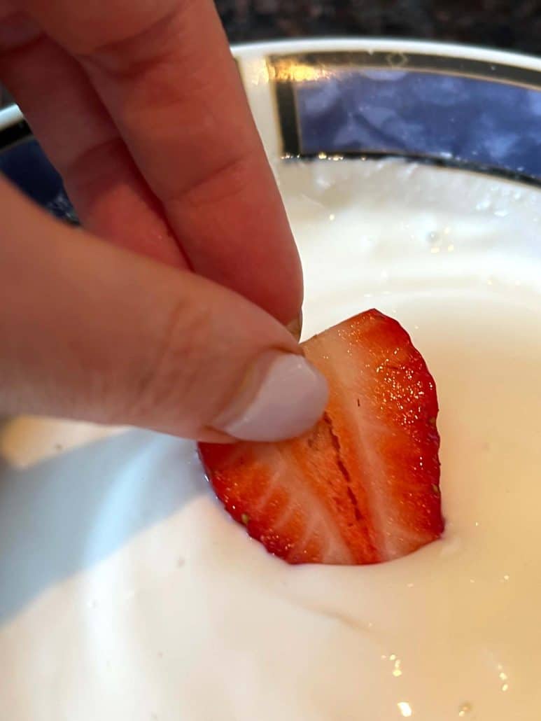 Close-up of creamy yogurt fruit dip with a fresh strawberry, 