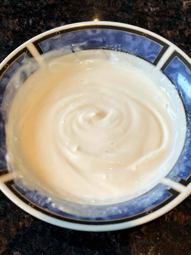 Top view of a finished dip made with Greek yogurt, smooth and creamy in texture, served in a bowl.