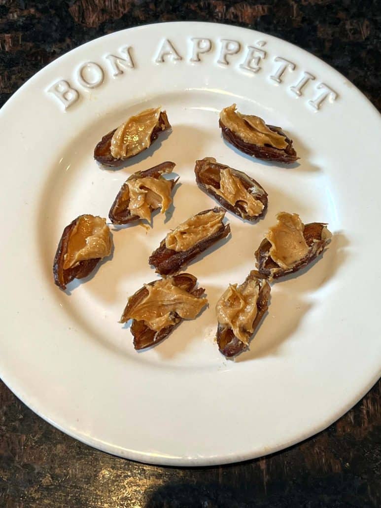 top view of peanut butter stuffed dates on a white plate.